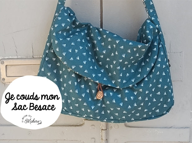 sac besace à coudre soi-même : imprimé de petites plumes sur fond bleu vert. Fermeture par bouton en bois